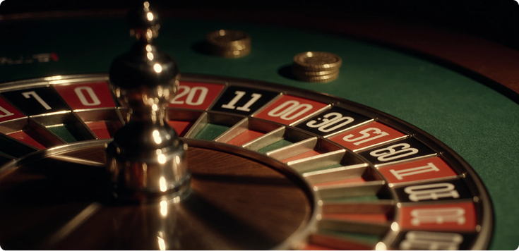 Close-up of an American Roulette wheel with the double-zero slot visible, featuring red and black numbers and a wooden frame